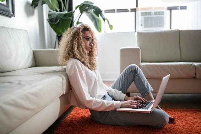 Black woman sitting on the floor with a laptop